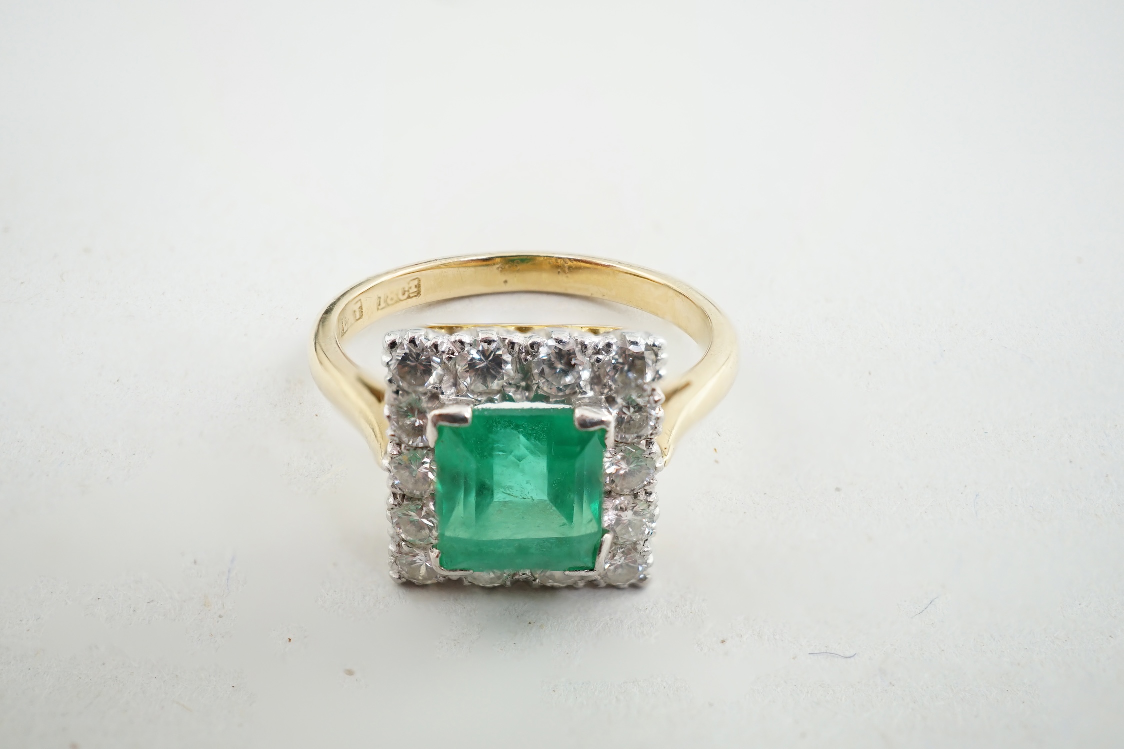 An 18ct gold and platinum, emerald and diamond set square cluster ring